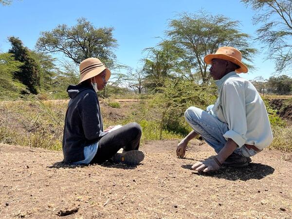 Dr. Veronica Waweru interviews a local collaborator who led the team of scientists to a fossil-rich site on the banks of the Ngobit River, Kenya